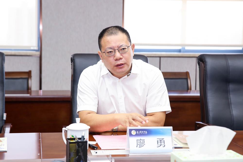 廖勇座谈学校党委常委,副校长韦俊平向客人介绍我校建设的广西民族